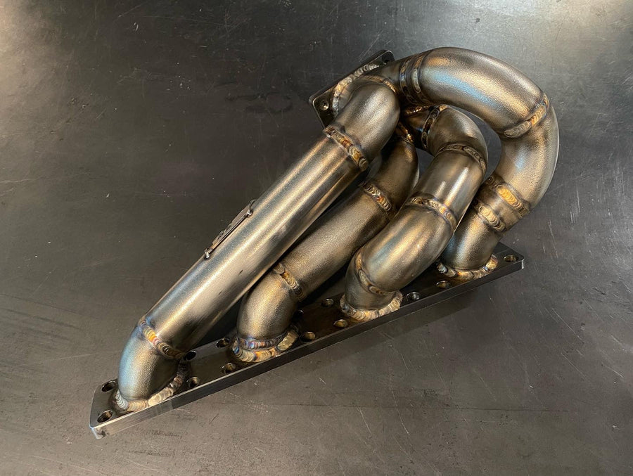 High-flow M42 turbo manifold built by DarkLight Fabrication for BMW E30
