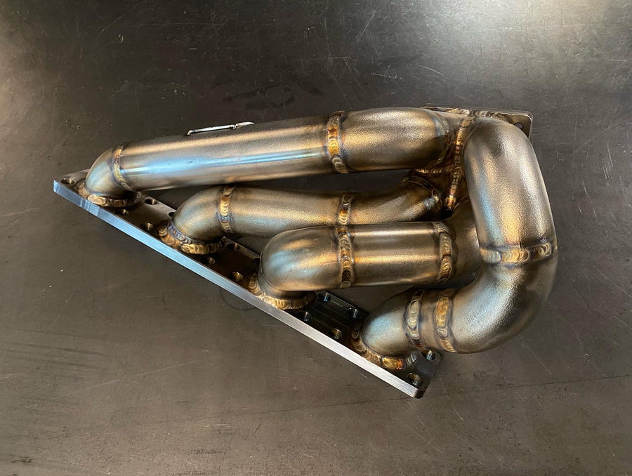 High-performance BMW E30 M42 turbo manifold built by DarkLight Fabrication